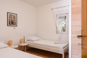 una piccola camera con due letti e una finestra di Apartment Planikovica a Trogir