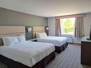 Best Western Plus Vancouver Airport Hotel في فانكوفر: غرفة فندقية بسريرين ونافذة