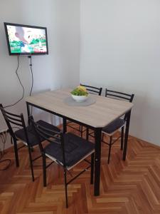 a dining room table with chairs and a bowl of fruit on it at Apartment Lucija in Dramalj