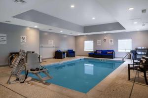 a swimming pool in a room with chairs and a couch at Microtel Inn & Suites by Wyndham Winchester in Winchester