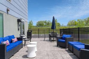 a patio with couches and tables and an umbrella at Microtel Inn & Suites by Wyndham Winchester in Winchester