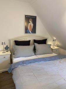 ein Schlafzimmer mit einem großen Bett mit zwei Nachttischen in der Unterkunft Anja in Westerland
