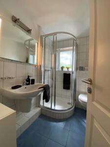 ein Bad mit einem Waschbecken, einer Dusche und einem WC in der Unterkunft Anja in Westerland