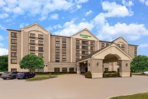 un edificio de hotel con un coche aparcado en un aparcamiento en Wyndham Garden Kansas City Airport, en Kansas City