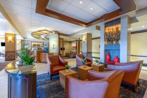 a lobby of a hotel with chairs and tables at Wyndham Garden Kansas City Airport in Kansas City