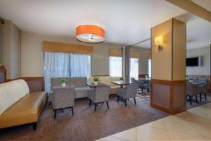 a living room with a couch and a table and chairs at Wyndham Garden Kansas City Airport in Kansas City