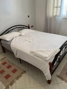 uma cama com lençóis brancos e almofadas num quarto em un appartement a loué em Essaouira