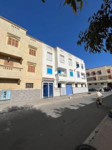 uma cabra a andar de bicicleta numa rua ao lado de um edifício em un appartement a loué em Essaouira