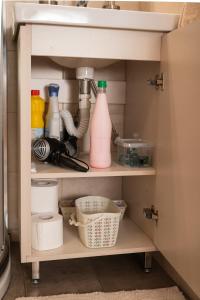 a kitchen cabinet with bottles and utensils at Plakoures Home in Kounoupidhianá