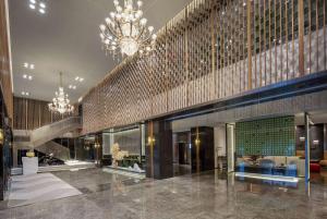 a large lobby with a chandelier and a building at Ramada by Wyndham Bayannur in Bayannur