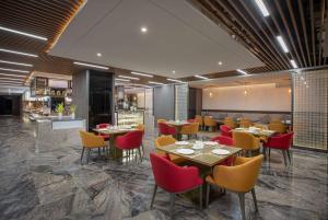 un ristorante con tavoli e sedie e un bar di Ramada by Wyndham Bayannur a Bayannur