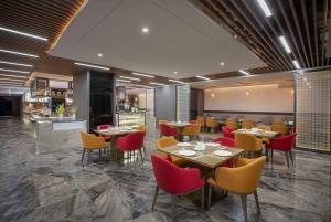 a restaurant with tables and chairs and a bar at Ramada by Wyndham Bayannur in Bayannur