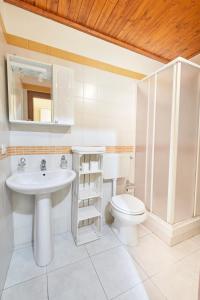 a white bathroom with a sink and a toilet at Centro Storico Rooms in Gallipoli