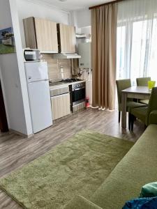 a kitchen with a white refrigerator and a table at Belle Sea View Apartment Mamaia in Mamaia