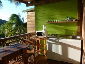 a kitchen with a sink and a microwave on a balcony at marie galante in Deshaies