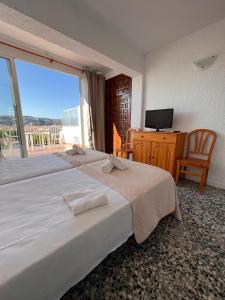 a bedroom with a large bed and a large window at Apartamentos Strand Jávea in Jávea