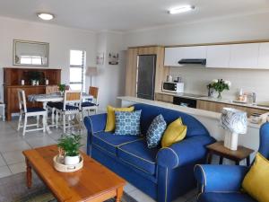 sala de estar con sofá azul y cocina en Ballito Beach Vibes at Ballito Hills, en Ballito