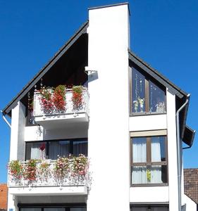 a white building with flower boxes on the balconies at Ihre Ferienwohnung mitten im Rhein-Main-Gebiet in Niederdorfelden