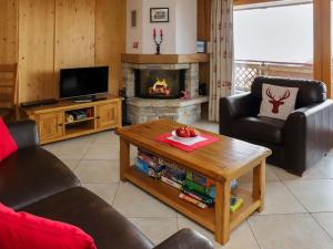 a living room with a table and a fireplace at Apartment Les Etagnes 2est by Interhome in Nendaz