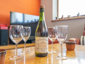 CléderにあるHoliday Home des Aulnes - CED209 by Interhomeのワインのボトル1本(テーブルに4杯のワイングラス付)