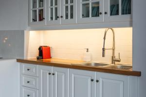 a kitchen with white cabinets and a sink at Blue Horizon Syrma in Klima
