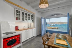 a kitchen with a table and a red oven at Blue Horizon Syrma in Klima