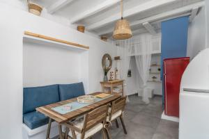 a dining room with a table and a blue couch at Blue Horizon Syrma in Klima +27 photos