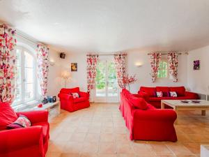 a living room with two red couches and a table at Holiday Home La Bastide Rose by Interhome in Sainte-Maxime