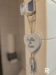 a heart on a bathroom wall with the words saddle be farm at Ô Centre- Chaleureux - Fibre - Netflix in Montargis