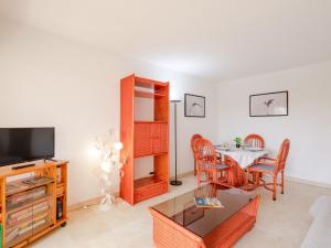a living room with a table and a television at Apartment Les Terres Marines by Interhome in Sainte-Maxime