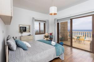 Un dormitorio con un osito de peluche sentado en una cama con balcón en Villa Beach Heaven, en Pomos