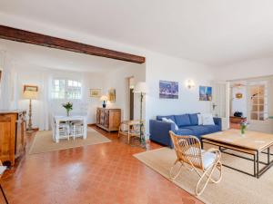 a living room with a blue couch and a table at Holiday Home Le Coba - MAX195 by Interhome in Sainte-Maxime