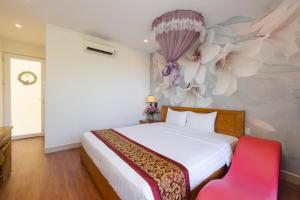 a bedroom with a bed with a flower mural on the wall at T&T Resort And Spa in Phú Quốc