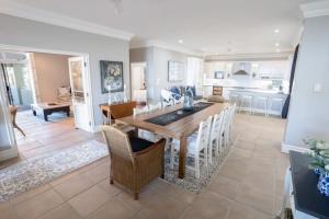 a kitchen and living room with a wooden table and chairs at Sole Haven in Southbroom
