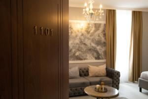 a living room with a couch and a chandelier at All Elevens 11 Apartments in Bitola