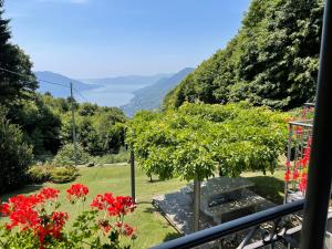 a view from the balcony of a garden with red flowers at Chalet Baita Lavu' by Interhome in Trarego