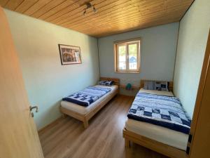 two beds in a room with a wooden ceiling at Holiday Home Strelasund by Interhome in Altefähr