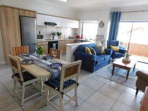 una cucina e un soggiorno con tavolo e divano blu di Ballito Beach Vibes at Ballito Hills a Ballito