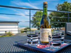 Una botella de vino y dos copas en una mesa. en Holiday Home Les Dunes - PNR224 by Interhome, en Plounéour-Trez