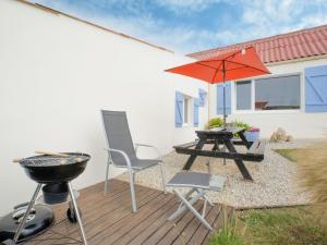 - une terrasse avec un barbecue, une table de pique-nique et un parasol dans l'établissement Holiday Home Ti an Aod - CED239 by Interhome, à Cléder