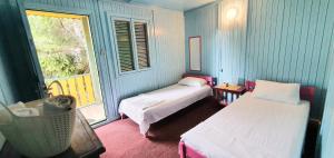 Habitación pequeña con 2 camas y ventana en Hotel Golden Sea, en Vama Veche
