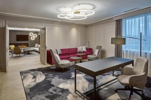 a living room with a red couch and chairs at Sheraton Zagreb Hotel in Zagreb