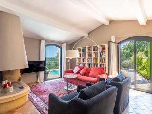 a living room with a red couch and a tv at Villa Le Pas de Courtin by Interhome in Bormes-les-Mimosas