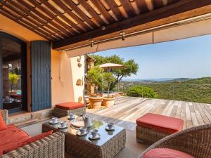 um pátio com uma mesa e cadeiras num deque em Villa Le Pas de Courtin by Interhome em Bormes-les-Mimosas