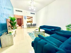 a living room with blue couches and a table at Luxurious Private Beach & Pool, fully Furnished 1BR Apartment at Marjan Island Ras al khaimah in Ras al Khaimah
