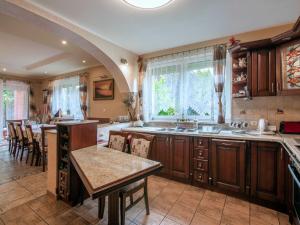 a kitchen with wooden cabinets and a table and chairs at Holiday Home Villa Bieszkowice by Interhome in Bieszkowice