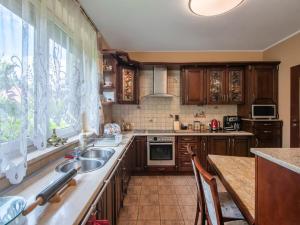 a kitchen with wooden cabinets and a sink and a window at Holiday Home Villa Bieszkowice by Interhome in Bieszkowice
