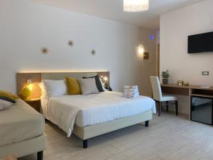 a bedroom with a bed and a desk with a computer at Esperidi Paestum Agri Resort in Capaccio-Paestum +28 photos