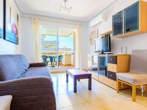 uma sala de estar com um sofá e uma televisão em Apartment Sea View - Jardines del Mar I by Interhome em El Borseral