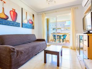 uma sala de estar com um sofá e uma mesa em Apartment Sea View - Jardines del Mar I by Interhome em El Borseral